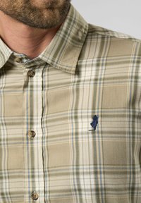 Geruite overhemd in beige, groen en blauwe tonen; heeft een klein marineblauw geborduurd logo, met een klassieke kraag en een gestructureerde stof.