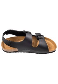 Sandalias negras con dos hebillas ajustables, plantilla de corcho y suela de goma texturizada; diseño minimalista y abierto.