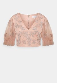 Blusa de cor pêssego com decote em V profundo, mangas bufantes transparentes e bordado floral em lantejoulas. Fecho de zíper nas costas e design ligeiramente cropped.