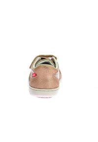 Chaussure à fermeture Velcro avec un revêtement métallique rose clair, bout rond, semelle blanche et détail de logo rouge sur le côté. Texture lisse sur l'ensemble.
