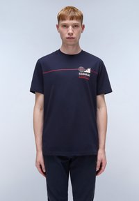 Camiseta de algodón azul marino de manga corta, con un diseño gráfico en rojo y blanco. Corte recto con cuello redondo y costuras mínimas.