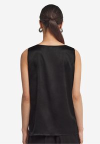 Haut sans manches noir en tissu lisse avec une coupe droite, présentant un décolleté arrondi et des bords nets.