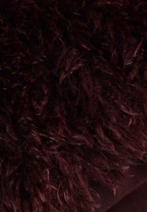 Burgundy shaggy textured fabric with long, loose fibers, layered over a smooth, dark base. Soft and plush appearance.