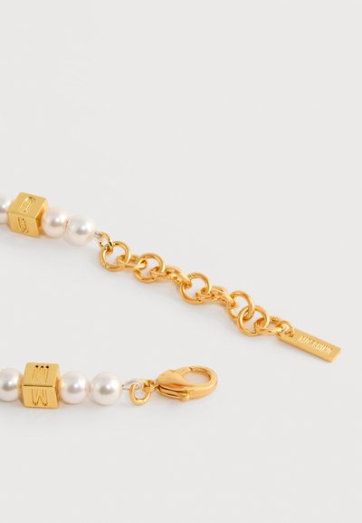 Collier chaîne en or avec fausses perles, perles cubes dorées gravées d'un "M", fermoir homard et chaîne réglable avec étiquette Moschino.