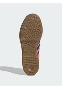 Λαστιχένια εξω�τερική σόλα με υφή, που διαθέτει κυκλικά και γεωμετρικά σχήματα. Ροζ ύφασμα επάνω μέρος με σκούρες μπλε ρίγες και λεπτομέρεια λογότυπου.