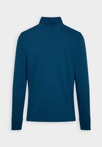 Långärmad polo i mörkblått, tillverkad av mjuk bomull, med krage och ribbade ärmslut. Slät yta utan synliga mönster.