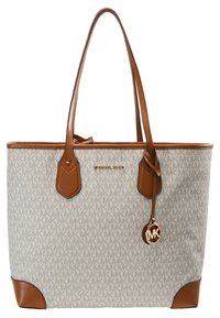 Sac cabas beige et marron avec motif du logo Michael Kors, anses en cuir marron, bordure et un pendentif doré MK suspendu.
