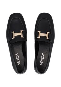 Zwarte leren loafers met een rechthoekige gouden gespdetail aan de voorkant, voorzien van een platte zool en een gladde textuur.