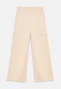 Wide-leg beige pants with elastic waistband and flap pockets on both sides, laid flat on a white background.
