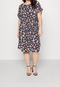 Kukkamekko tummansinisellä pohjalla, jossa vaaleanpunaisia ja valkoisia kukkia. Pehmeä kangas, lyhyet hihat, joustava vyötärö ja polvipituus. Yhdistetty mustiin korkokenkiin.