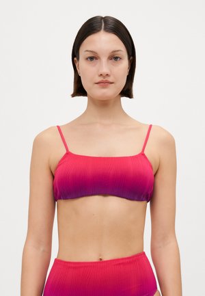 Bikinitopp i gradient rosa tyg med ribbad textur. Har tunna justerbara axelband och en rak halsringning. Slät, minimalistisk design.