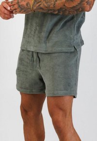 Grå frottéshorts med dragsko i midjan, sidofickor och subtil logotypdetalj vid fållen, som erbjuder en avslappnad passform och mjuk textur.
