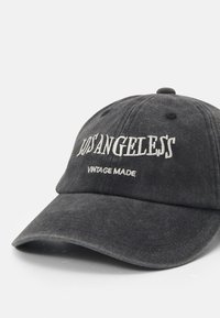 Svart bomullslue med buet skjerm, med hvit brodert tekst "LOS ANGELES" og "VINTAGE MADE," som presenterer en vintage stil.
