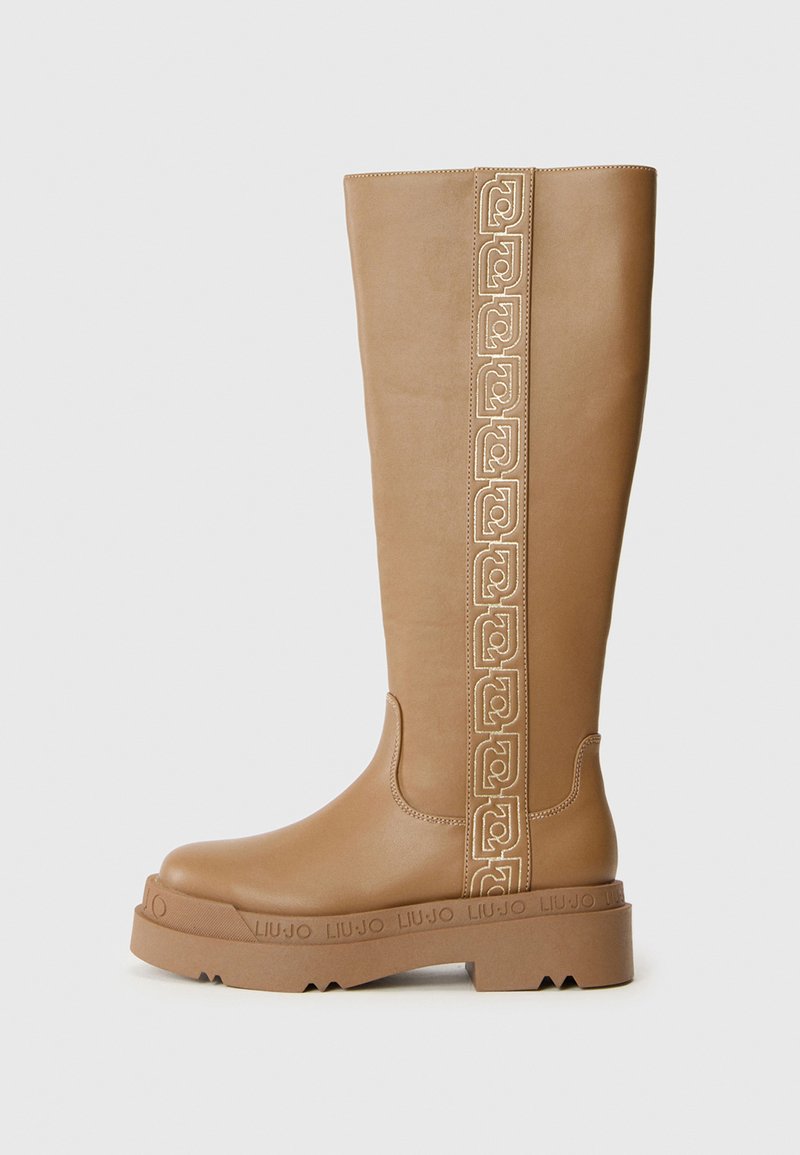 Hohe, tanfarbene Lederstiefel mit dicker Sohle, eingeprägtem Markennamen auf der Sohle und dekorativem, vertikal genähtem Muster an der Seite.