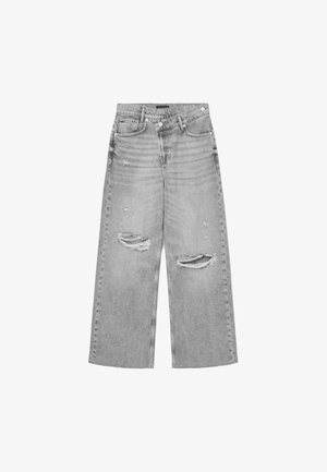 Jasnoszare dżinsy o szerokich nogawkach z przetarciami, z dziurami na kolanach, pięcioma kieszeniami i zapięciem na guzik w pasie.