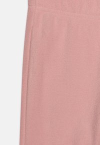 Helles rosa Fleece-Material mit weicher Textur, glatter Oberfläche und subtiler Schimmerung, ideal für Freizeitkleidung oder Loungewear.