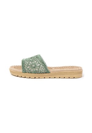 Sandalia de suela beige con una gruesa banda de crochet verde con diseño floral y plantilla texturizada, vista de lado sobre fondo blanco.