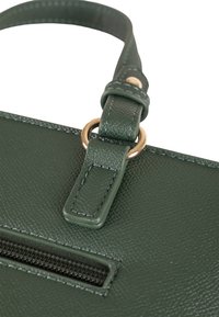 Borsa a tracolla in pelle verde testurizzata con un anello in metallo dorato, dotata di una cintura decorativa con dettaglio di cucitura e una tasca con cerniera.