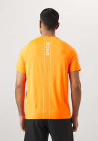 Orange athletic shirt featuring a crew neck, short sleeves, with a white vertical "BORG" logo and contrasting white seam detail.