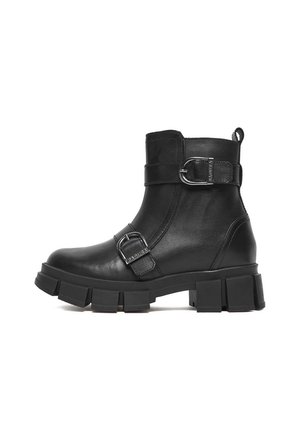 Czarny skórzany botek za kostkę z masywną podeszwą i dwoma regulowanymi paskami z klamrami, jednym wokół kostki i jednym przy palcach.