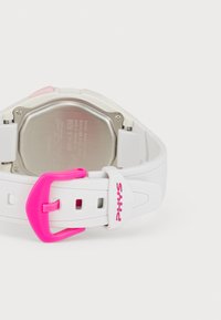 Montre numérique blanche avec un dos en acier inoxydable, des accents matériels roses et un bracelet texturé. Dotée d'une boucle rose et d'un logo de marque.