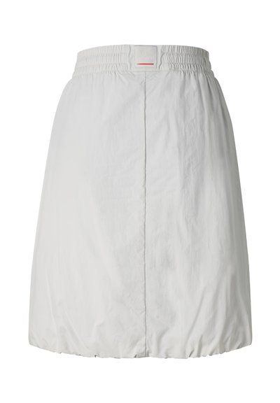 Jupe blanche longueur genou avec taille élastique et ourlet froncé, avec une couture verticale centrale et un petit patch logo rectangulaire à la taille.
