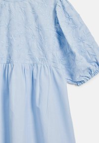 Světle modré bavlněné šaty s vyšitými květinovými vzory, nabíranými rukávy a skladaným pasem pro rozšířenou siluetu.