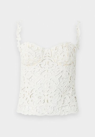 Λευκό crop top από δαντέλα με περίτεχνα λουλουδένια και σπιράλ σχέδια, με λεπτούς, διακοσμητικούς ιμάντες ώμων και εφαρμοστό σχεδιασμό στο στήθος.