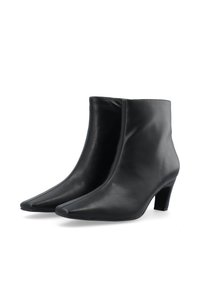 Bottines en cuir noir avec un design à bout pointu et un petit talon. Texture lisse et détails de couture minimalistes.