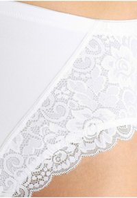 Weisse Baumwollslips mit einem zarten Spitzenbesatz mit Blumenmustern an den Kanten, die eine glatte Textur und ein dezentes Design zeigen.