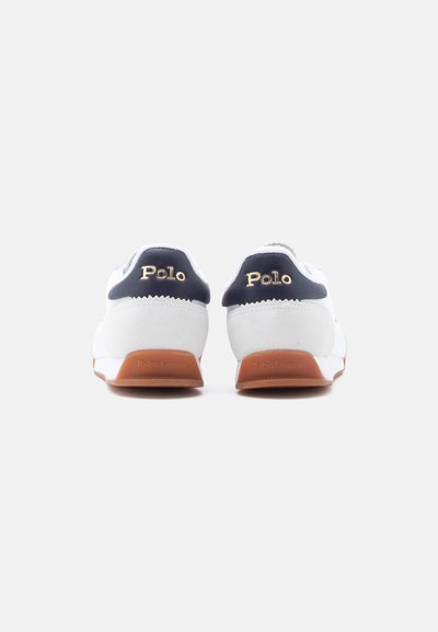 Hvite joggesko med blå lær-detaljer, semsket hel og brun gummiyttersåle. Har gullfarget "Polo"-logo på hælen.