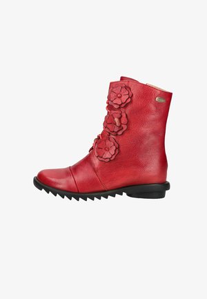 Roter Leder-Stiefelette mit drei dekorativen Blumenapplikationen und schwarzer, gerippter Sohle, Seitenansicht vor weißem Hintergrund.