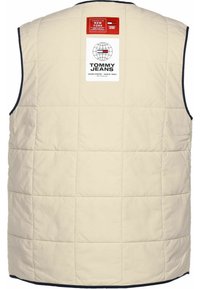 Beige quiltad väst med marinblå kant, med en stor rektangulär Tommy Jeans-logotyp och kvadratiska sömnadsmönster.