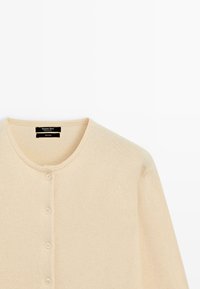 Hellbeiger Wollcardigan mit Rundhalsausschnitt, sechs Knöpfen und langen Ärmeln. Weiche Textur und minimalistisches Design ohne Muster.