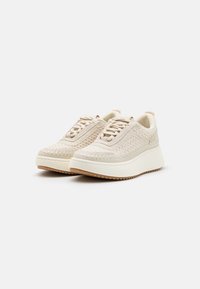 Beige vævede sneakers med en tekstureret overdel, snørelukning og en tyk hvid platformssål med et rillemønster.