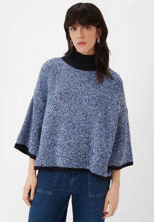 Blau und schwarz gestrickte Poncho mit hohem Kragen, ausgestattet mit einem strukturierten Muster und weiten Ärmeln. Der Saum ist schwarz eingefasst.