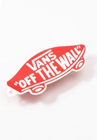 Červený samolepka ve tvaru skateboardu s logem Vans "Off The Wall" s tučným bílým textem na bílém pozadí.