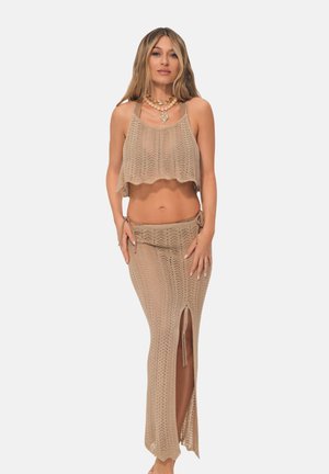 Beige knitted crop top and long skirt set, featuring a textured crochet design, side slit, and adjustable tie details.