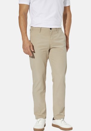 Beige chinos made of cotton blend fabric, featuring a straight-leg cut, front pockets, and a button closure, paired with white sneakers.