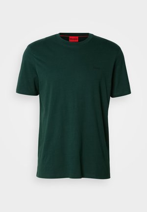 Mörkgrön t-shirt med korta ärmar gjord av mjukt tyg. Har en rund halsringning och en liten logotyp i svart på vänster bröst.