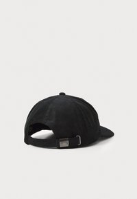 Schwarze Cord-Baseballmütze mit gebogenem Schirm, verstellbarem Riemen hinten und einem Metall-Logo-Akzent am Riemen. Texturierte Stoffoberfläche.