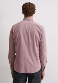 Koszula z długim rękawem w kolorze przykurzonego różu z bawełny, z klasycznym kołnierzykiem, guzikami przy mankietach i zaokrąglonym dołem, prezentująca gładką fakturę.