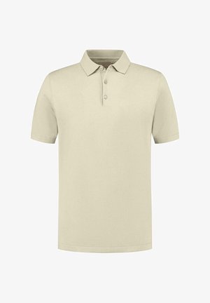 Polo beige à manches courtes, col classique, patte de boutonnage à trois boutons et détail de logo discret sur la poitrine. Tissu lisse et texturé.
