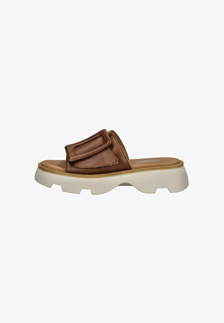 Sandales à glissière en cuir marron avec une large sangle ornée d'une boucle carrée, une semelle en caoutchouc blanc épais et une semelle intérieure ergonomique pour le confort.