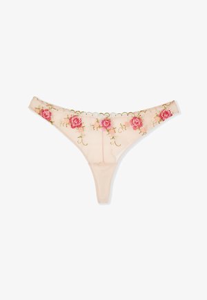 String beige transparent avec des motifs floraux brodés roses et rouges et des bords festonnés le long de la ceinture.