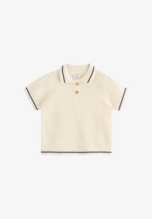 Kremfarvet strikket polo t-shirt med korte ærmer og tekstureret mønster, to knapper og navyblå kant på krave, ærmer og kant.