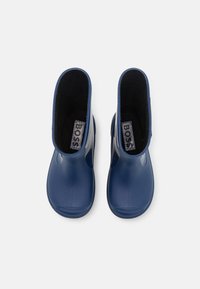 Bottes en caoutchouc bleu avec une finition lisse, dotées d'une doublure noire texturée et d'une étiquette à l'intérieur. Design de hauteur mi-mollet.
