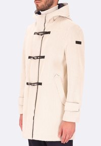 Cappotto a righe beige con cappuccio, dotato di chiusure a toggle nere, tasche laterali e un tessuto testurizzato. Maniche lunghe con dettagli sui polsini.