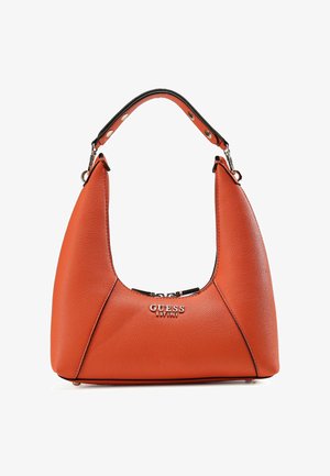 Orangefarbene Lederhandtasche mit geschwungener Silhouette, schwarzem Kontrastriemen, silbernen Beschlägen und geprägtem "GUESS"-Logo auf der Vorderseite.