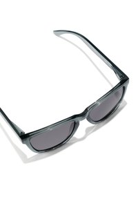 Occhiali da sole grigi con forma rettangolare, montatura in plastica semi-trasparente e lenti scure. Texture liscia senza ulteriori dettagli decorativi.